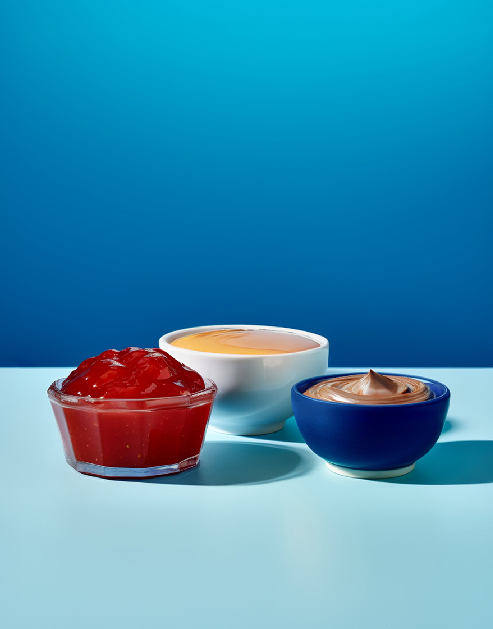 Schüsseln mit Marmelade, Honig und Nussnougatcreme
